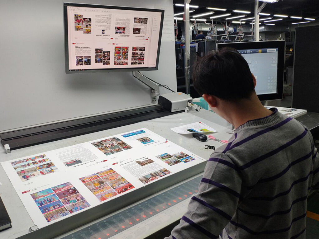 Operario de preimpresión que revisa las páginas de un libro antes de su producción