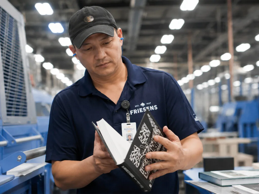 Workers inspecting finished books in a printing factory